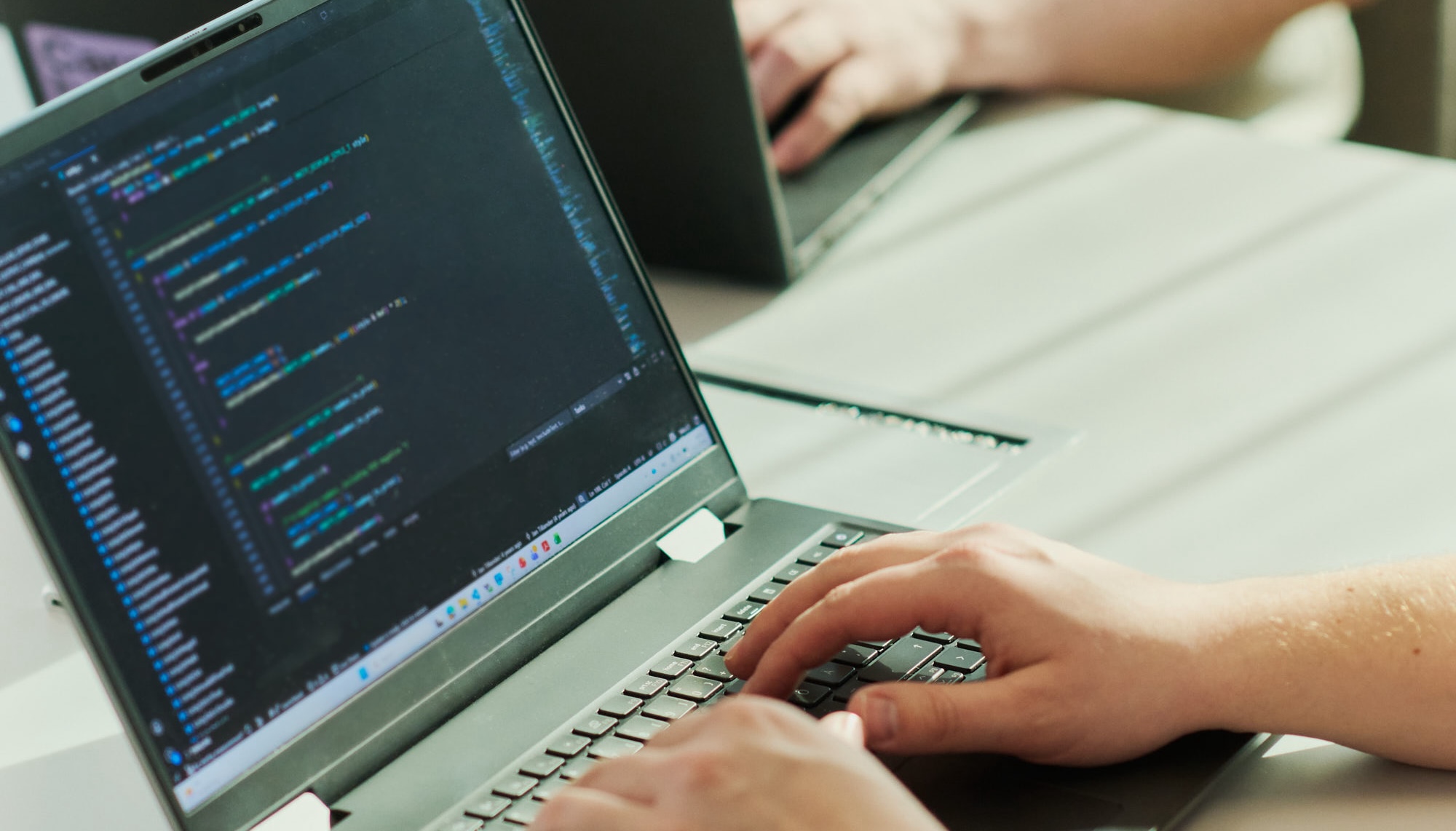 A close-up of laptop and hands on key boards typing.